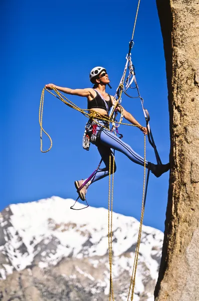 Mulher alpinista agarrada a um penhasco . — Fotografia de Stock