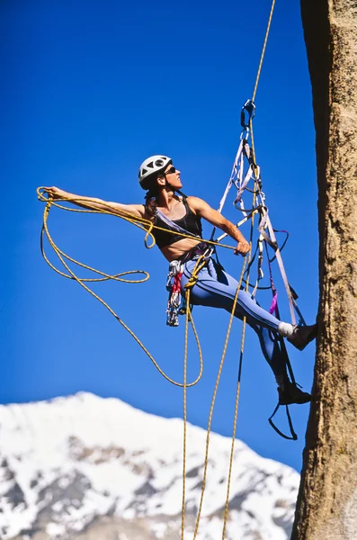 Femme grimpeuse accrochée à une falaise . — Photo