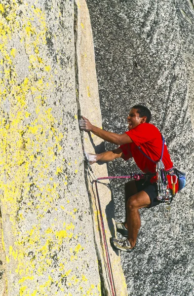 Escalador de rocas aferrado a un acantilado . — Foto de Stock