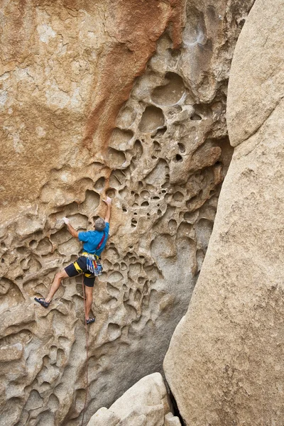Homem alpinista agarrado a uma borda do penhasco — Fotografia de Stock