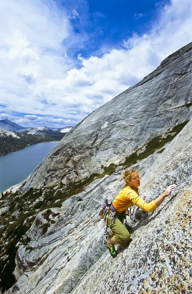 Mujer escaladora aferrada a un acantilado . — Foto de Stock