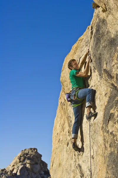 Climber clinging to a cliff. Stock Photo