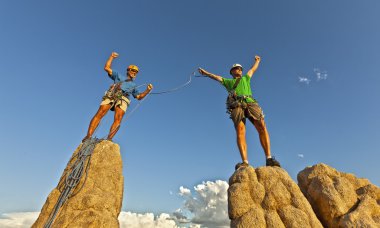 Rock climbing team reaching the summit. clipart