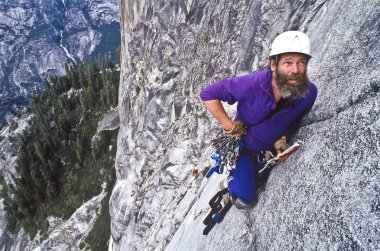 Rock climber ascending Half Dome. clipart