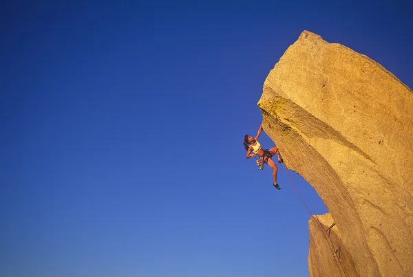 Female climber clinging to the edge. — Stock Photo, Image