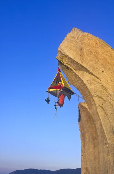 Klimmer en zijn kamp bungelend uit een klif. — Stockfoto