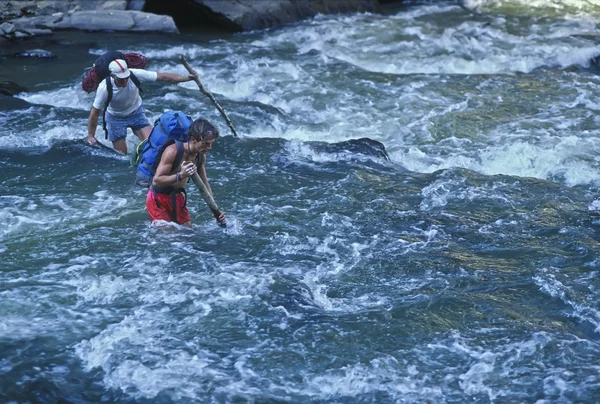 Senderistas cruzando un río . — Foto de Stock