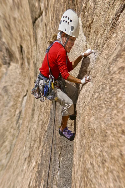 Női mászó kapaszkodva egy szikláról. — Stock Fotó