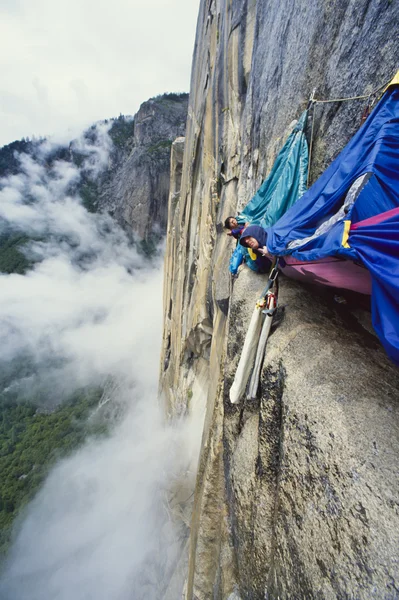 岩の壁にしがみついている登山チーム. — ストック写真