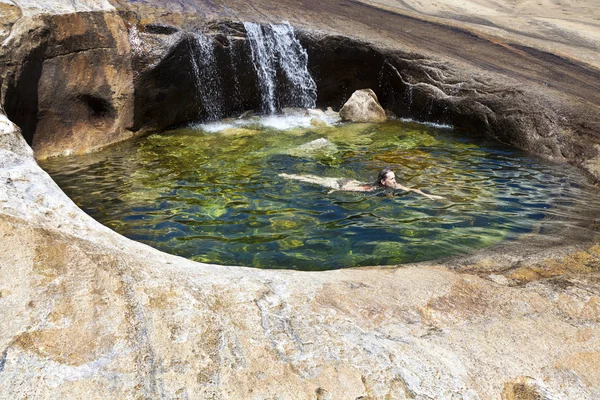 Frau schwimmt in einem natürlichen Pool. — Stockfoto