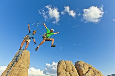 Rock climbing team reaching the summit. clipart