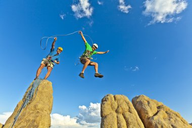 Rock climbing team reaching the summit. clipart