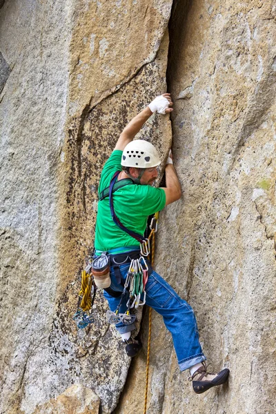 Bergsteiger kämpft sich die Klippe hinauf. — Stockfoto