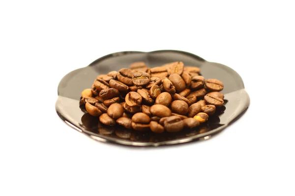 Granos de café en un plato sobre un fondo blanco — Foto de Stock