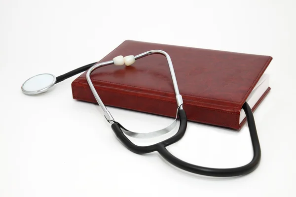 Cuaderno con estetoscopio médico — Foto de Stock