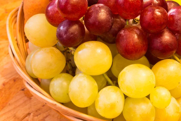 stock image White and red grapes in wickerwork basket