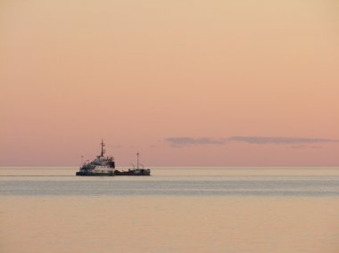 Evening calm sea with the ship clipart