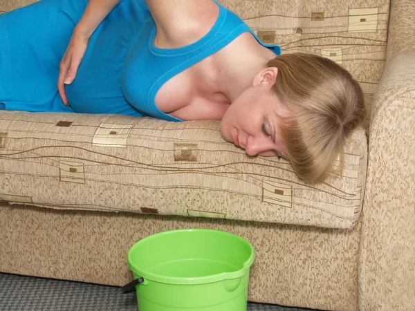 Toxicosis. La mujer embarazada yace en un sofá — Foto de Stock