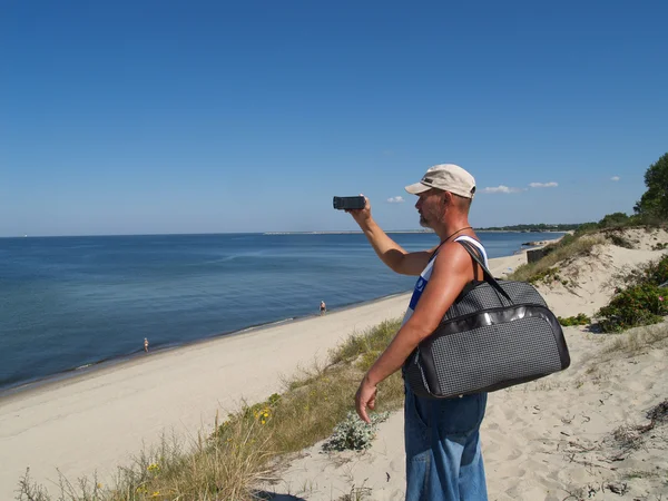 Stock image The man removes coast of the Baltic plait on a videocamera