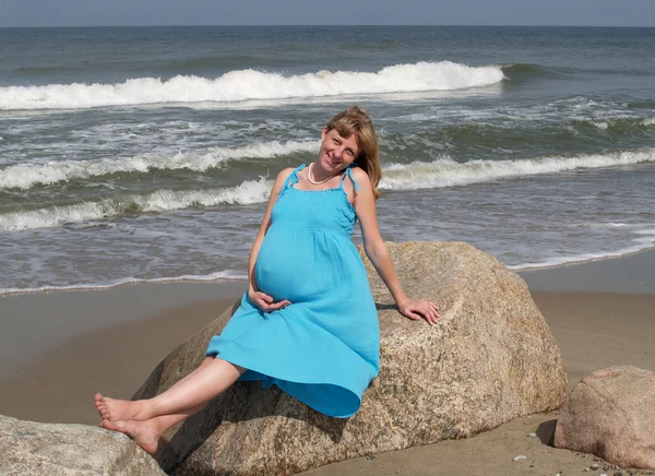 Těhotná žena uvolňující na břehu Baltského moře — Stock fotografie