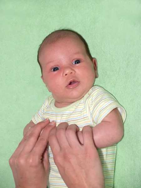 Mains de maman tenir les poignées du bébé — Photo