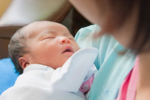 Ασίας θηλυκό νεογέννητο στην αγκαλιά της μητέρας Εικόνα Αρχείου