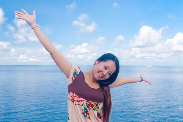Asian girl raise arms at sea — Stock Photo, Image