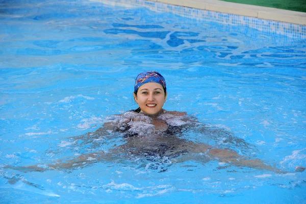 Schönes junges lächelndes Mädchen, das im Pool im Halstuch segelt — Stockfoto