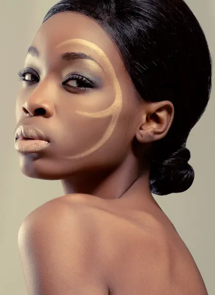 Closeup beauty shot of a young woman with golden makeup — Stock Photo, Image
