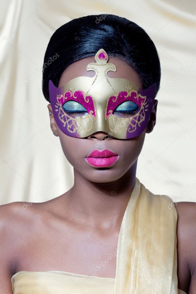 Beautiful young woman wearing a golden carnival mask