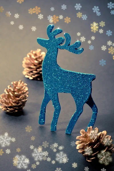 Christmas decorations: reindeer figure and golden pine cones — Stock Photo, Image