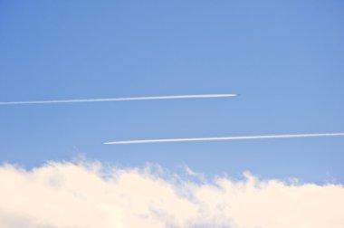 Airplane vapour contrails against vivid blue sky clipart