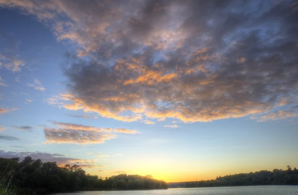 Яркий красочный закат над спокойным рыбацким озером с отражениями — стоковое фото