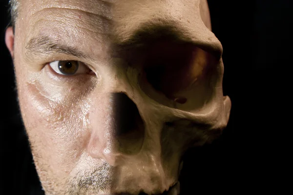 Eng haalloween concept van halve gezicht halve schedel zichtbaar op donker — Stockfoto