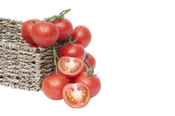 Fresh ripe vine tomatoes in rustic basket with sliced tomato iso — Stock Photo, Image