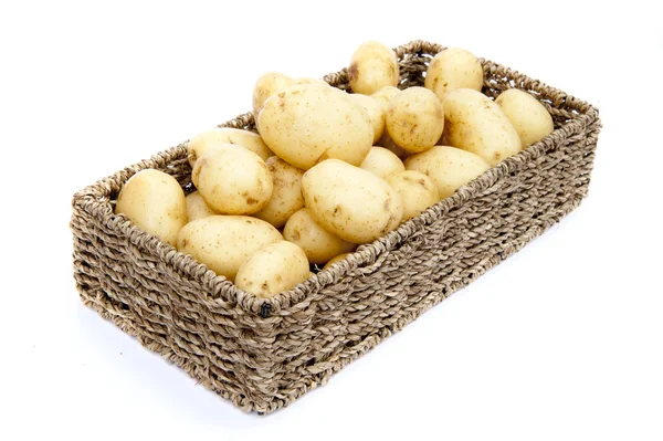 stock image Fresh new potatoes in rustic basket isolated on white background