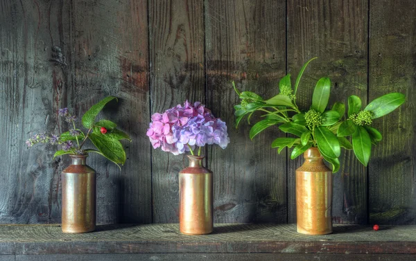 Retro stil stilleben av torkade blommor i vas mot slitna woo — Stockfoto
