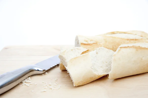 Bageta a chléb nůž na prkénko, izolované na bílém — Stock fotografie