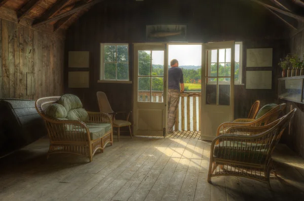 Ov 外を眺める男とノスタルジックなレトロな効果夏のボートハウス — ストック写真