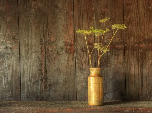 Retro stijl stilleven van gedroogde bloemen in vaas tegen gedragen woo Stockfoto