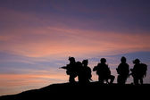 Silhouette of modern troops in Middle East silhouette against be