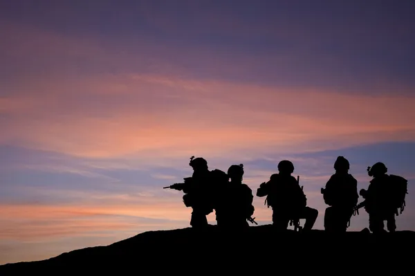 Silhouette of modern troops in Middle East silhouette against be — Stock Photo, Image