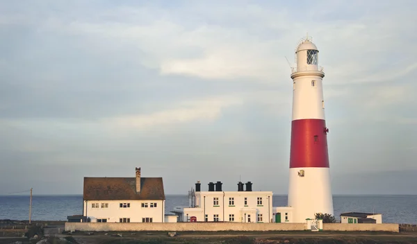 Stock image Victorian lighthouse on promontory of rocky cliffs