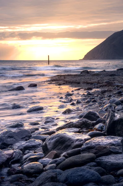 Mooie warme levendige zonsopgang boven de oceaan met kliffen en rotsen — Stockfoto