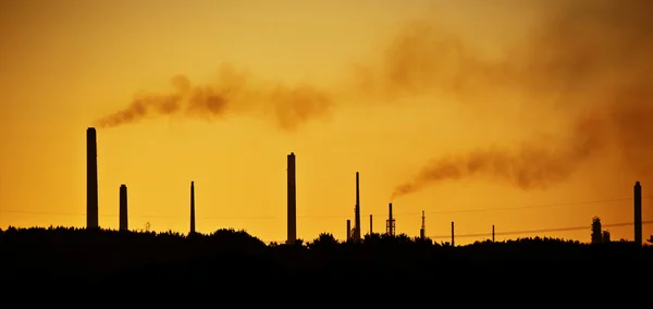 Industrial chimney stacks in natural landscape polluting the air — Stock Photo, Image