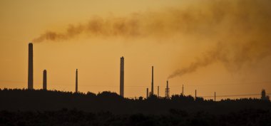 Industrial chimney stacks in landscape polluting the air clipart