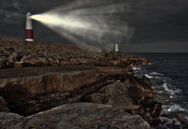 Victorian lighthouse on promontory of rocky cliffs with beam ali clipart