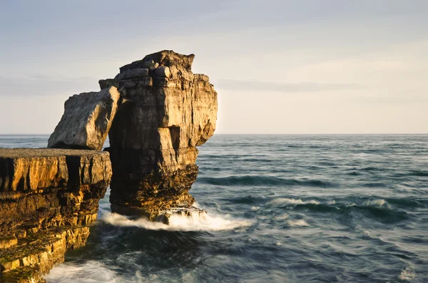 Impresionantes formaciones geológicas de acantilados rocosos con olas estrellándose — Foto de Stock