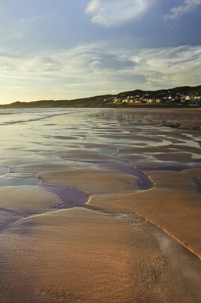 Ponto de vista baixo ao longo da praia ao pôr do sol com excelente detalhe em textu areia — Fotografia de Stock