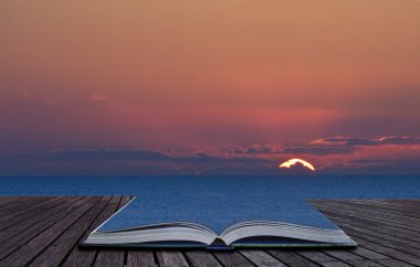 Magical book with contents spilling into landscape background clipart